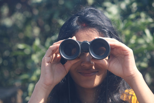 A woman is looking through binoculars.