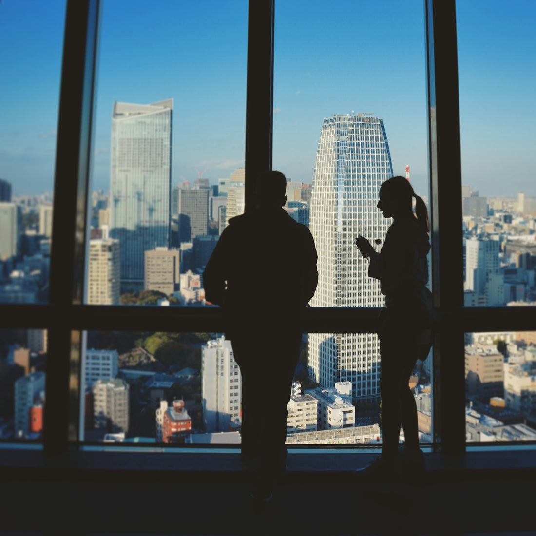silhouette of man standing in front of glass window