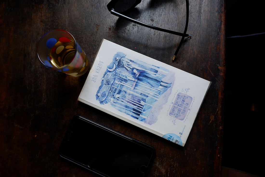 white and blue book on brown wooden table