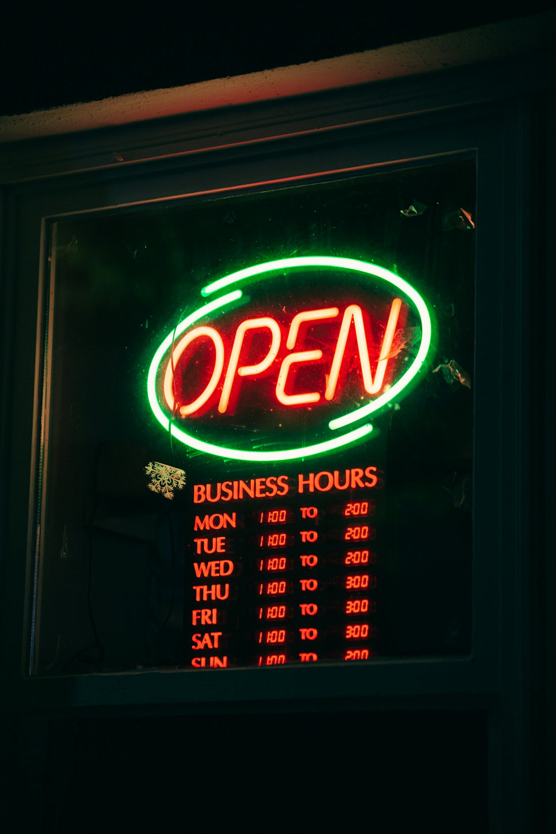 a neon sign that reads open business hours