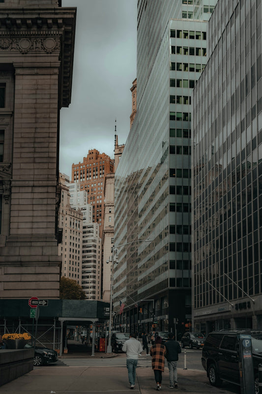 a group of people walking down a street next to tall buildings