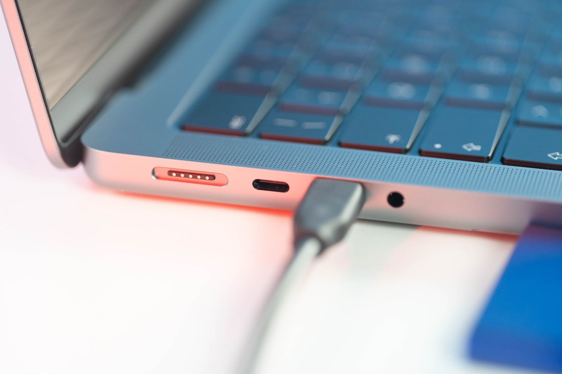 a close up of a laptop with a charger plugged in