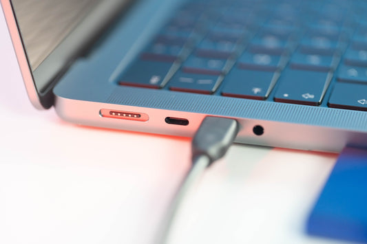 a close up of a laptop with a charger plugged in