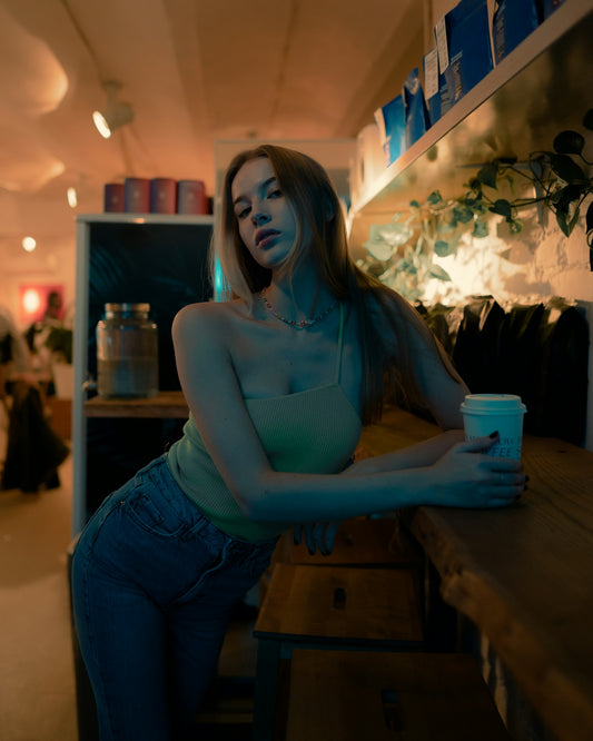 a woman sitting at a counter with a cup of coffee