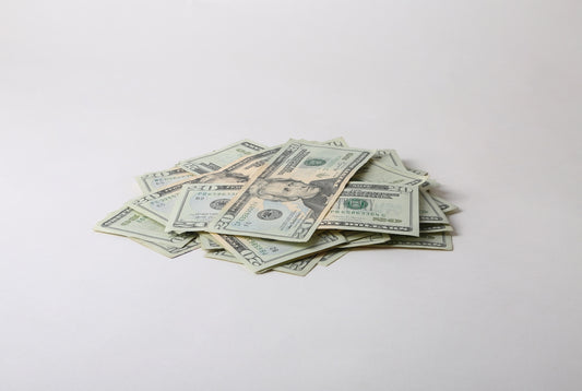 a pile of money sitting on top of a white table