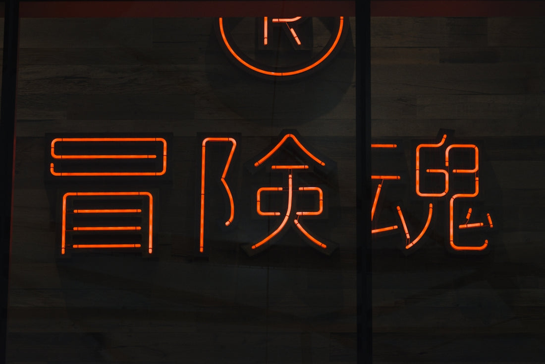 a neon sign with asian writing on it