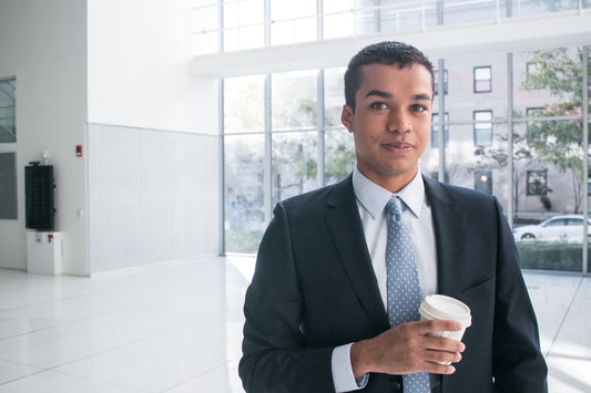 a man in a suit holding a cup of coffee