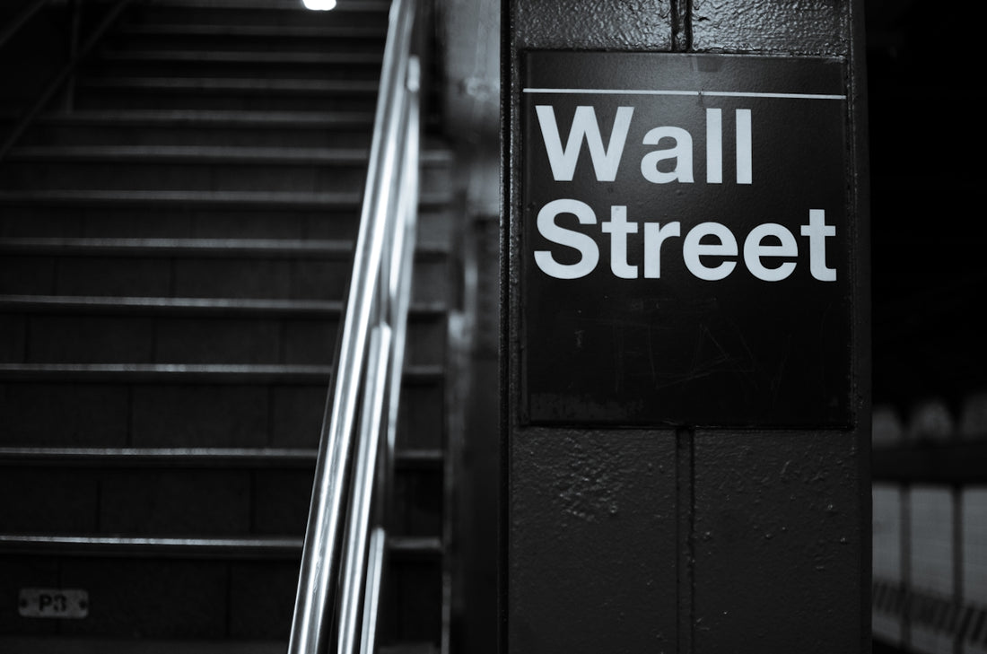 a black and white photo of a wall street sign