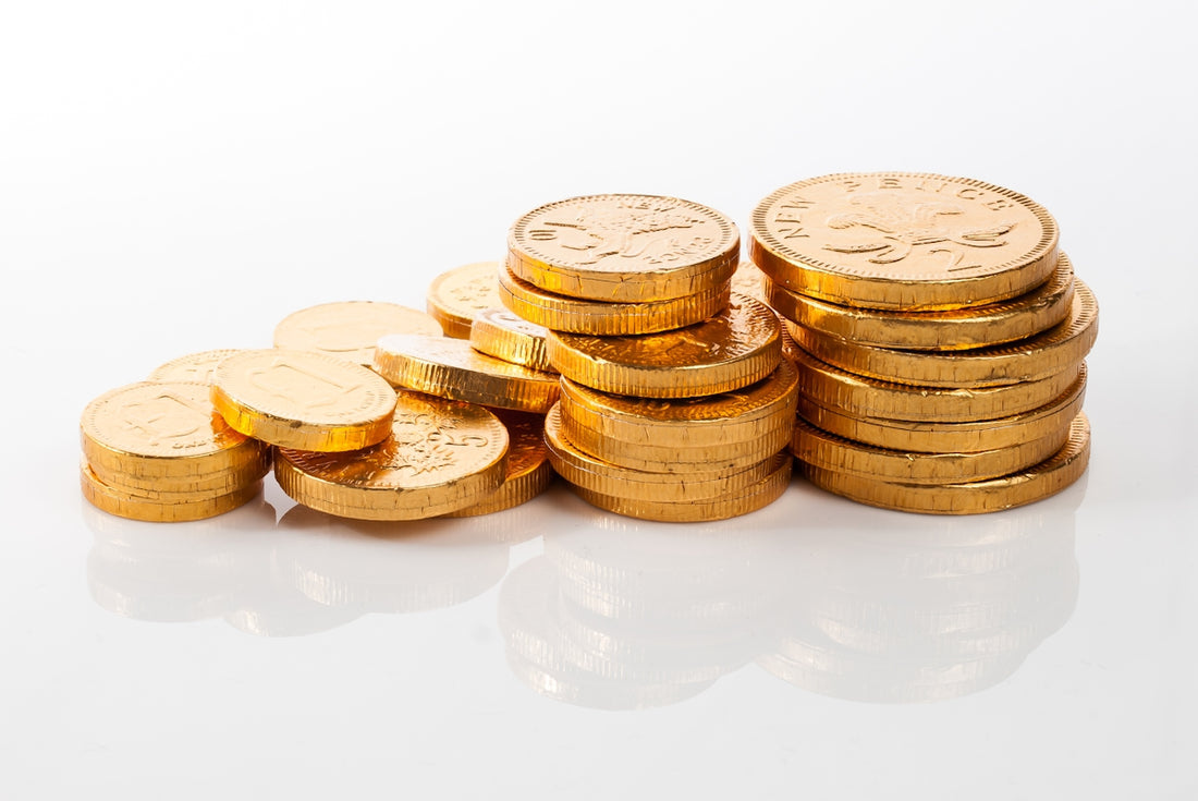 a pile of gold coins sitting on top of a white table