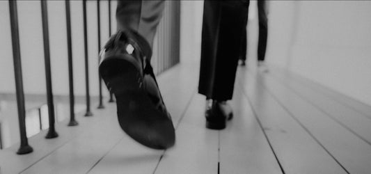 a person walking down a wooden floor next to a railing