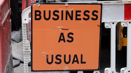 A sign that says business as usual on it
