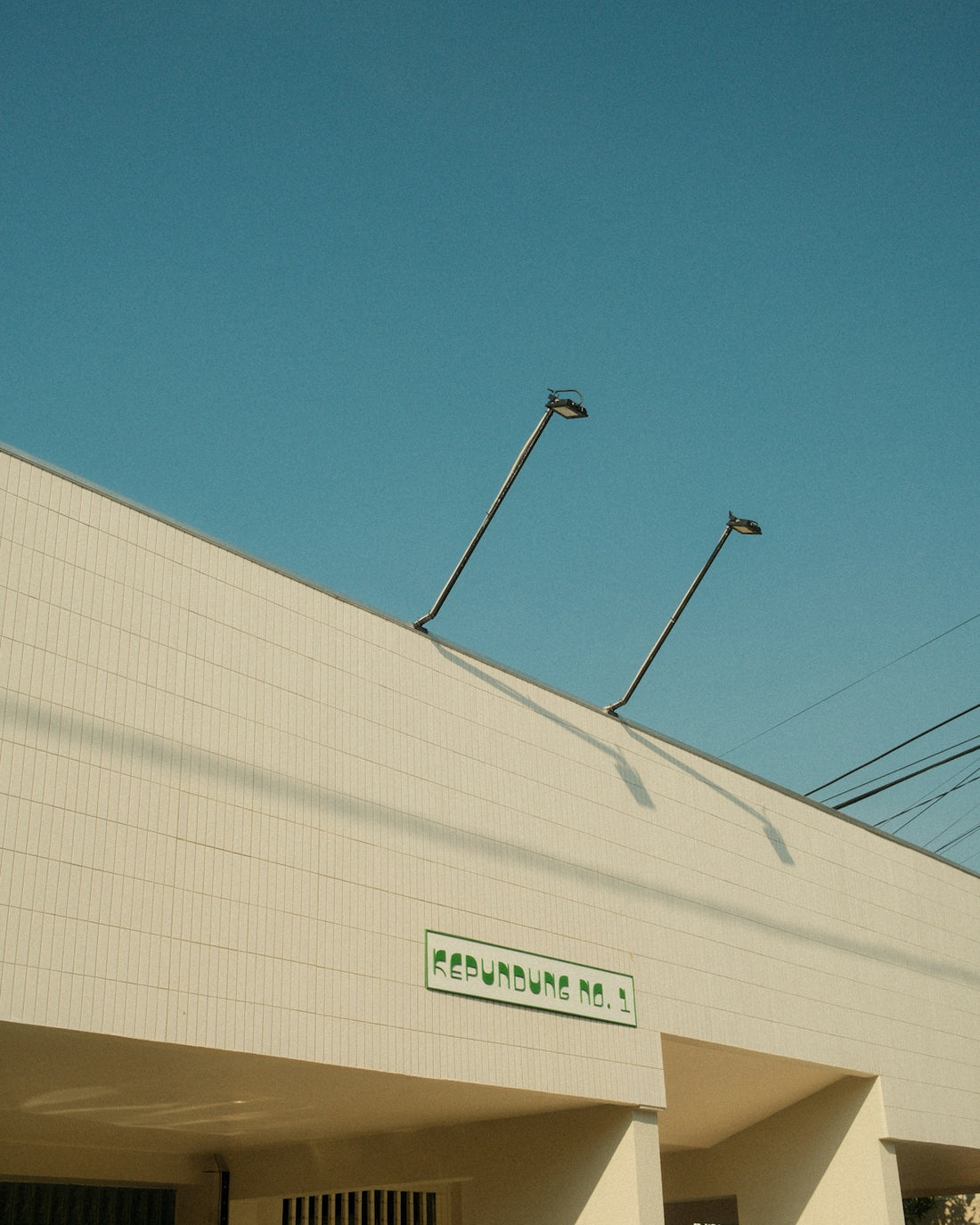 A tall white building with a street light on top of it