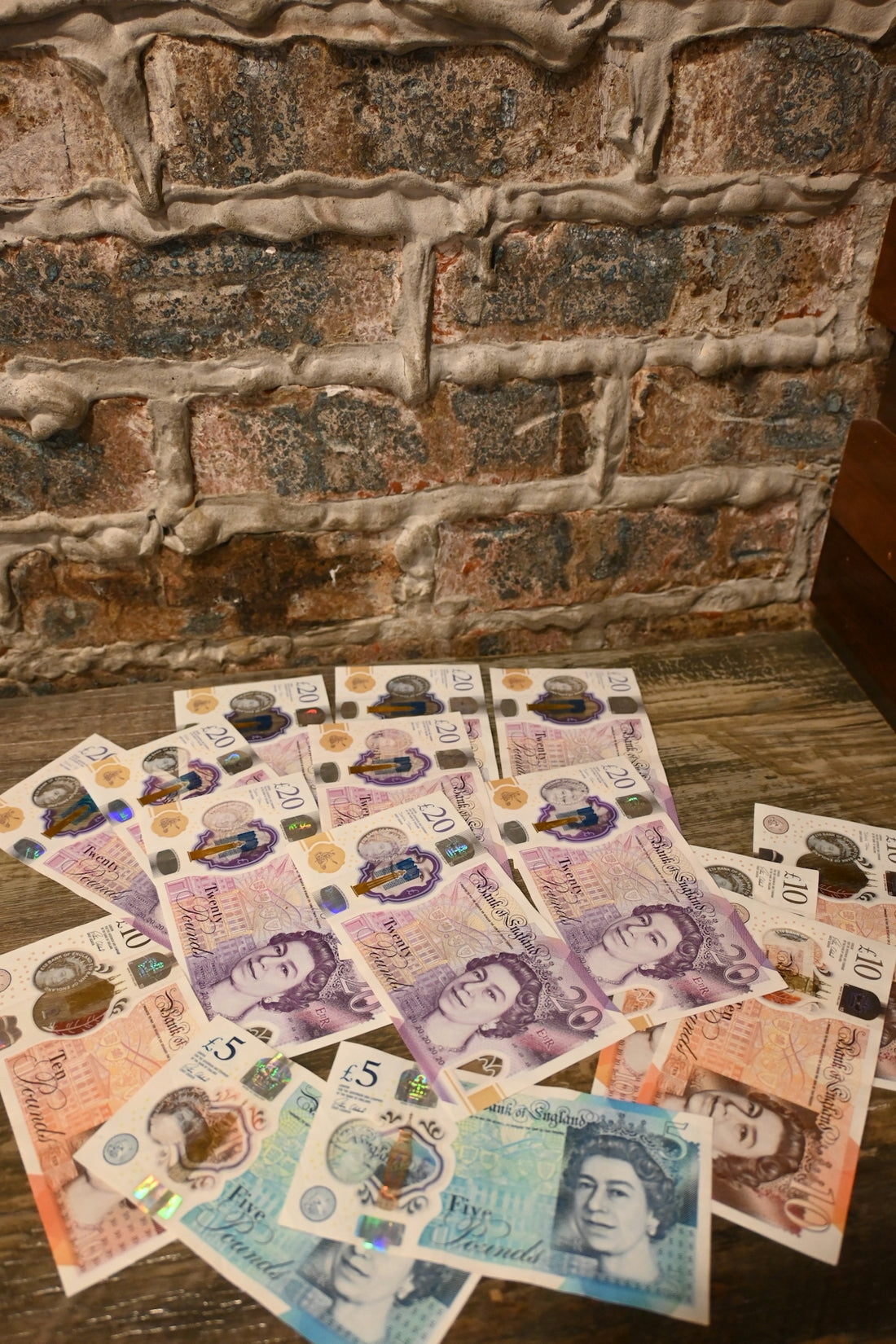 A pile of foreign currency sitting on top of a wooden table
