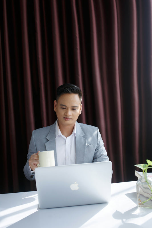 A man sitting at a table in front of a laptop computer