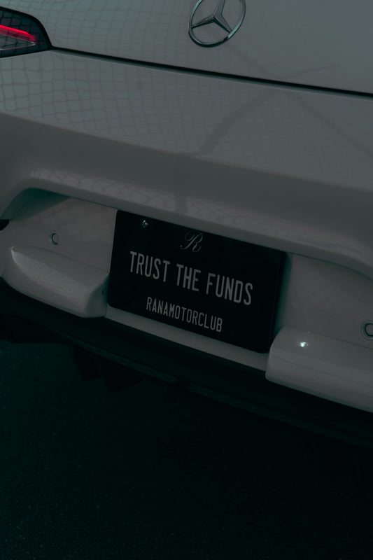 A close up of a white car with a sign on it