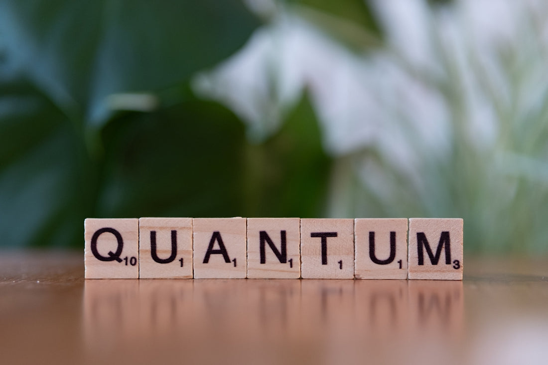 A wooden block spelling the word quanntum on a table