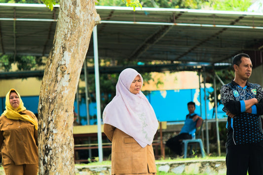 People stand outside, observing an event.