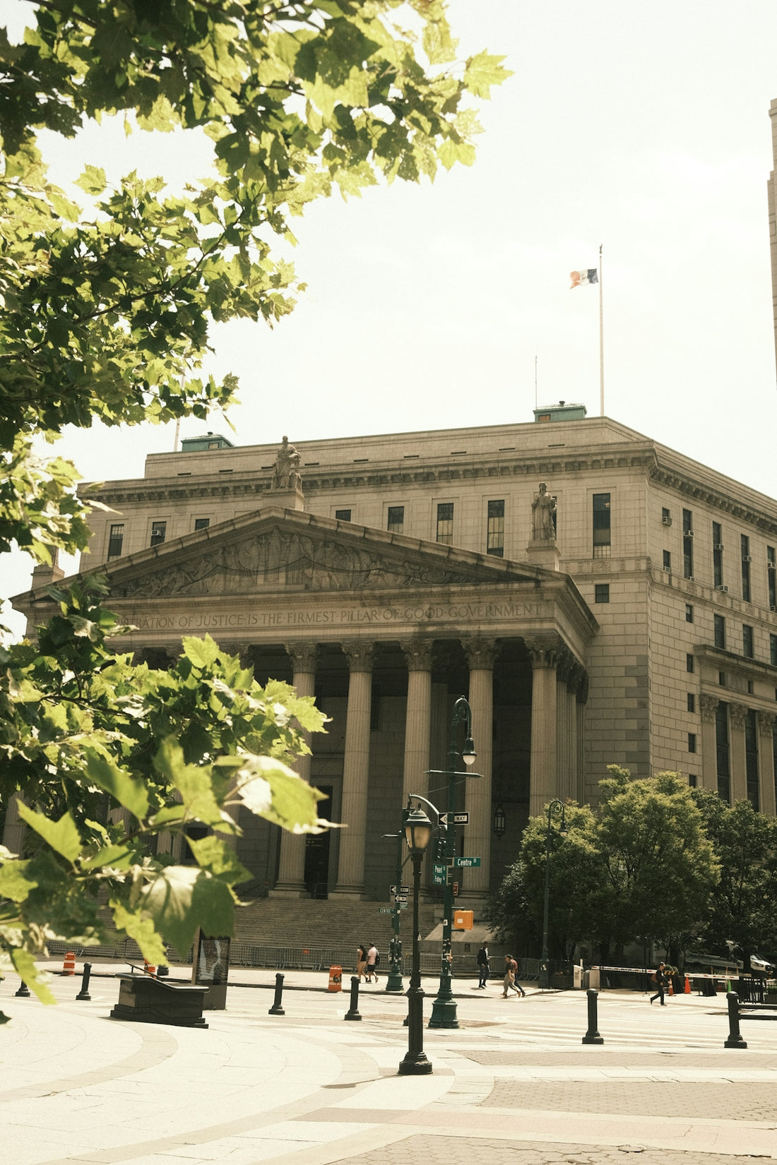 A courthouse stands tall with columns and trees.