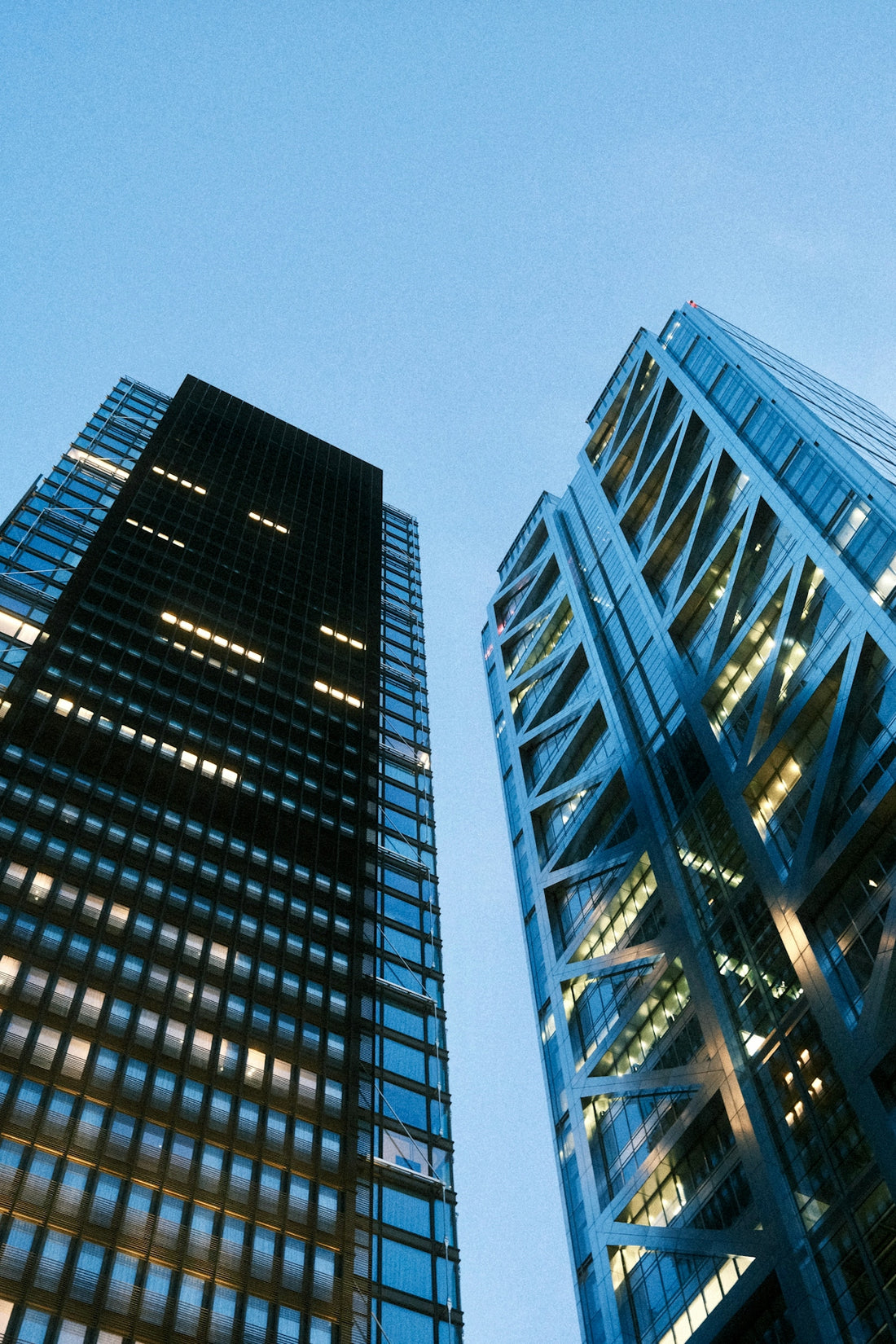Modern glass skyscrapers against a clear blue sky.