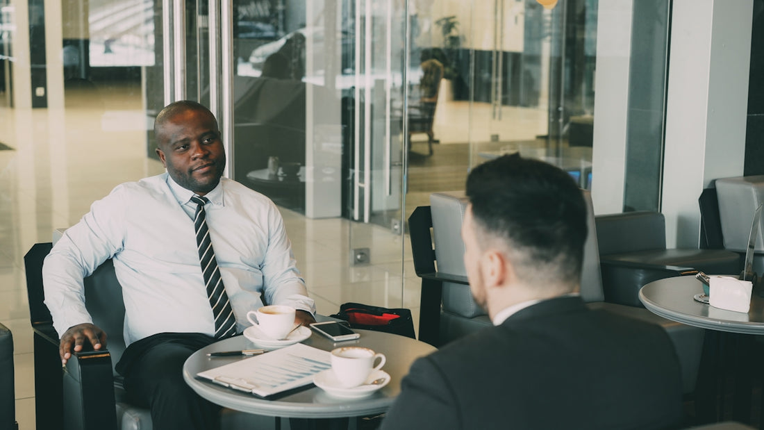 Two businessmen talking at a cafe table.
